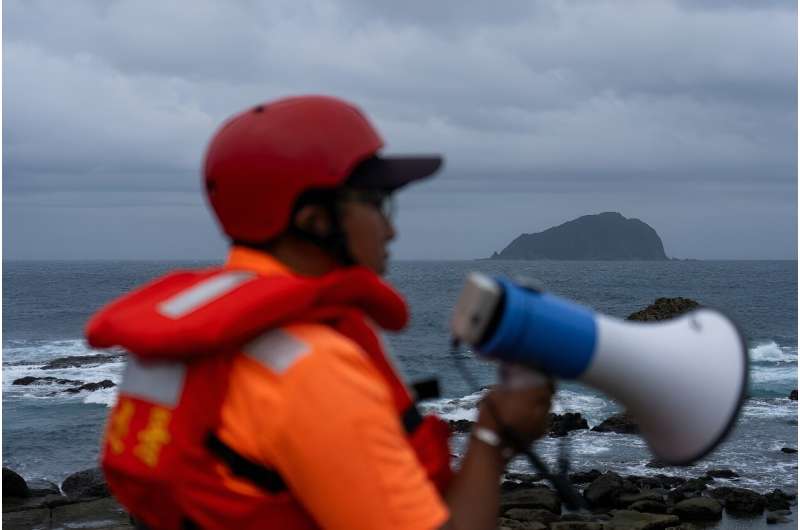 A coast guard member keeps watch for people nearing the coast in Taiwan's Keelung as Typhoon Krathon nears